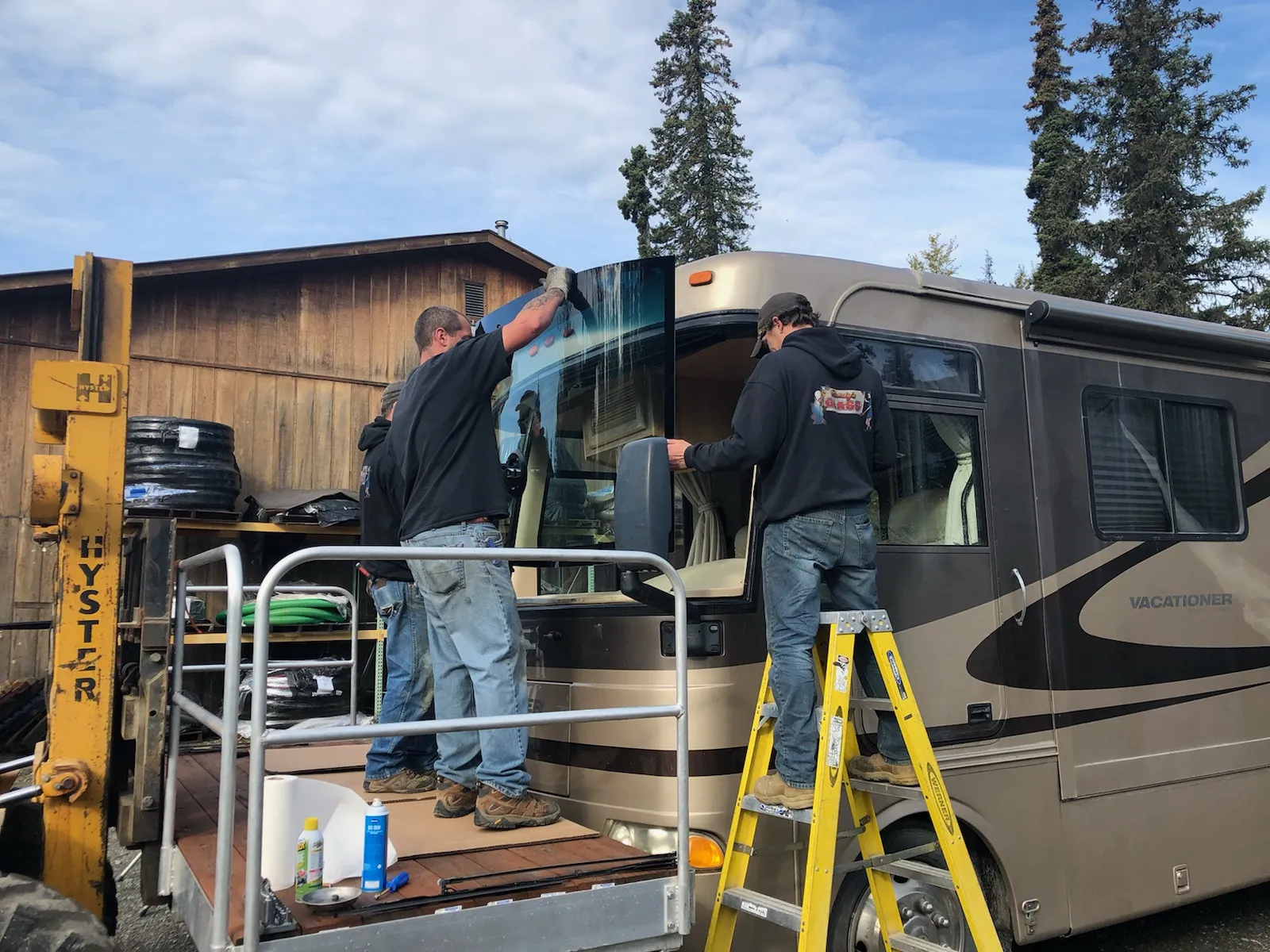 Randy’s Glass crew fitting a large windshield into the front of a motorhome
